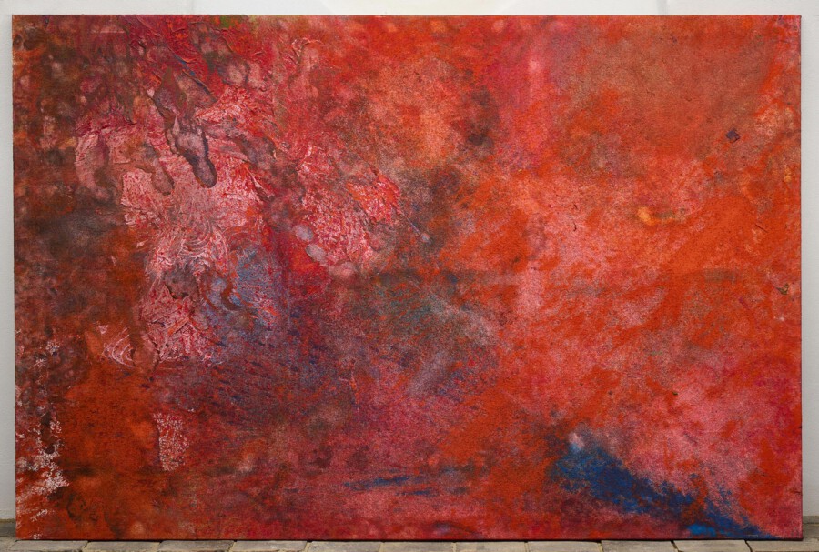 Abstrakte Malerei in Rot- und Ockertönen, strukturierte Oberfläche; auf Leinwand, an einer Wand aufgehängt.